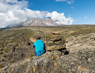 Hiker contemplating majestic mount kilimanjaro in tanzania.