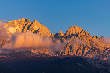 Naklejka premium The view of Yulong Snow Mountain bathed in sunlight on the golden Mountain