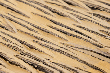 Close up of cardboard with cuts forming a texture for abstract backgrounds. Recycling, shipping concept