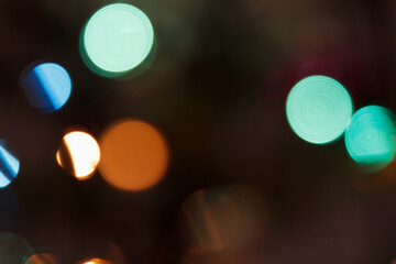 Colorful bokeh lights in various shades of blue, green, orange, and yellow create a vibrant, abstract background