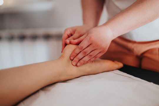 Close up of therapeutic foot massage, promoting relaxation and well-being in a calming setting, showcasing professional care and the rejuvenating benefits of bodywork for increased comfort and health.