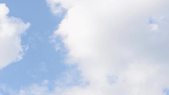 White clouds float peacefully against a clear blue sky in Holland, creating a tranquil and beautiful scene.