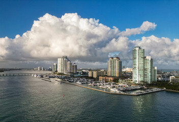 Fototapeta premium Marina Bay filled with vessels and yacht in Miami. Summer vacation scene with yachts by the oceanfront. Skyline with yachts in Miami. Florida coastline from above with boats. Boat trip in the Miami.