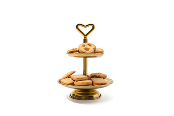 Cookies on Gold Cake Stand White Background. Danish butter cookies are elegantly displayed on a two...