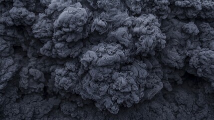 Dense, textured clusters of dark grey smoke or ash billow and swirl, creating an intense and dramatic visual effect.