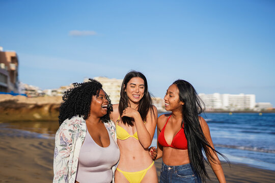 Group of multiracial young women having fun together on the beach during summer vacation - Female friendship, diversity and travel concept