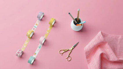 Top-Down View of Decorative Tapes, Stationery Holder, Scissors, and Cloth on Pink Surface for Crafting, Scrapbooking, and Creative Projects with Pastel Colors and Clean Aesthetic