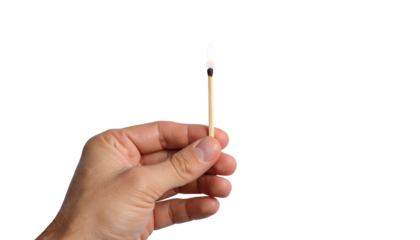 Closeup of hand striking a match, igniting flame of new beginnings