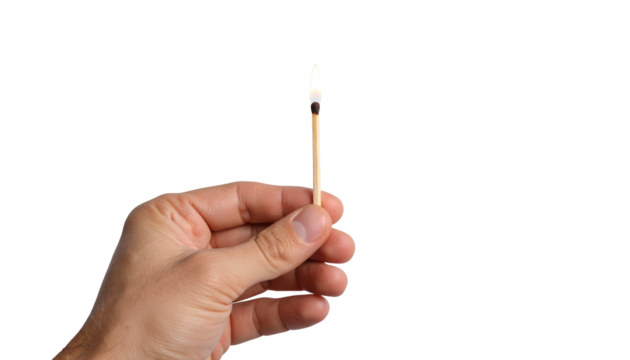 Closeup of hand striking a match, igniting flame of new beginnings