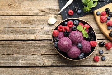 Delicious sorbet, fresh berries and mint on wooden table, flat lay. Space for text