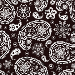 Illustration showing a seamless pattern of white paisleys and floral designs on a dark brown background