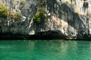 A limestone cliff green water of sea on Phang Nga bay of Thailand, near Phuket province.