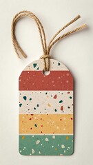 Colorful terrazzo gift tag with twine hanging on a light background
