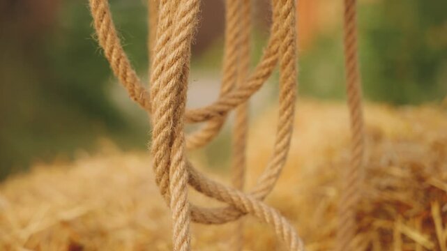 lasso rope lies hanging on log wooden fence. Close up shot object item rope twine. cowgirl western country style wild west. Concept rodeo ranch hitching post. Summer nature sun light flare sunset 4k