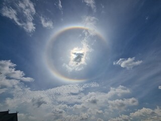 Sun Halo: An awe-inspiring halo encircles the sun, creating a breathtaking visual phenomenon amidst a canvas of dramatic clouds and a vast, open sky.