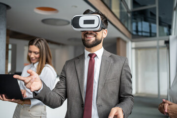 Businessman wearing virtual reality headset gesturing in modern office