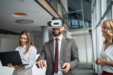 Businessman wearing vr headset interacting with virtual reality in modern office, colleagues watching him