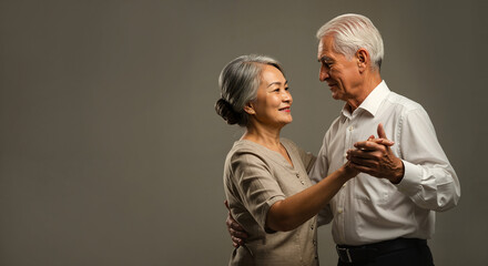 Korean elderly couple dancing waltz in studio