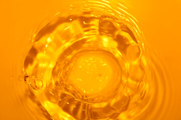 Vibrant Close-up of Rippling Water Surface in Golden Hue and Light