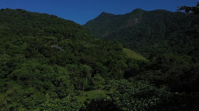Aerial view of a mountainous and preserved region of the Atlantic Forest, a tropical rainforest in Rio de Janeiro, Brazil. The beauty and biodiversity are the highlights.
