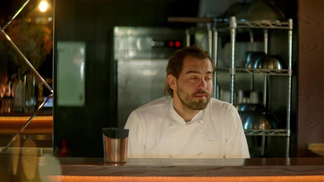 TRACKING Chef working on commercial restaurant kitchen, checking new orders on a display. Shot with 2x anamorphic lens