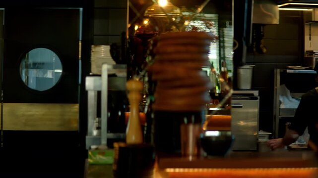 TRACKING Caucasian male chef walking in commercial restaurant kitchen through the swinging doors. Shot with 2x anamorphic lens
