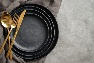 Black plates with golden cutlery present elegant dining concept, ideal for restaurant menus, blog posts, web design, and marketing materials.