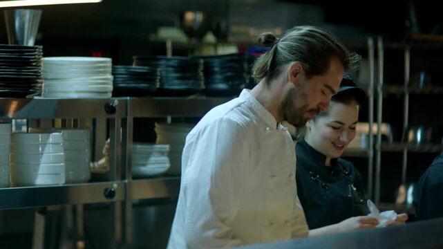 Portrait of Caucasian male chef working on busy commercial restaurant kitchen. Shot with 2x anamorphic lens