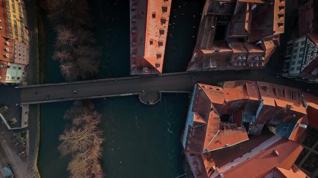 Aerial view of a Untere bridge, Old town hall, buildings with red roofs, creating a striking contrast with the dark water flowing beneath it, winter Bamberg, Bavaria, Germany.