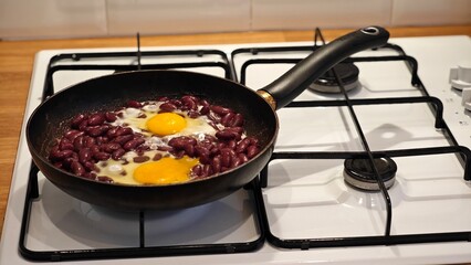 Cooking kidney beans and eggs on a gas stove in a cozy kitchen during a weekend brunch