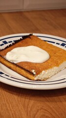 A delicious cottage cheese casserole with sour cream, served on a plate with a blue border