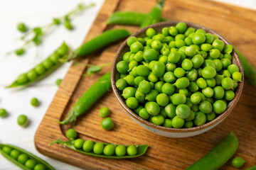 Fresh green pea pods with green peas on a wooden background. Sweet green peas. Green pea beans vegetables. Vegan. healthy vegetable. Copy space