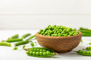 Fresh green pea pods with green peas on a wooden background. Sweet green peas. Green pea beans vegetables. Vegan. healthy vegetable. Copy space
