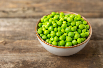 Fresh green pea pods with green peas on a wooden background. Sweet green peas. Green pea beans vegetables. Vegan. healthy vegetable. Copy space