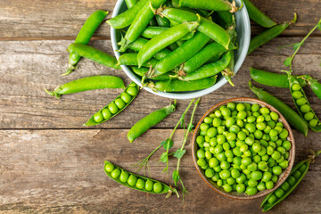 Fresh green pea pods with green peas on a wooden background. Sweet green peas. Green pea beans vegetables. Vegan. healthy vegetable. Copy space