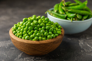 Fresh green pea pods with green peas on a wooden background. Sweet green peas. Green pea beans vegetables. Vegan. healthy vegetable. Copy space