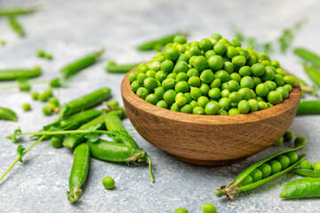 Fresh green pea pods with green peas on a wooden background. Sweet green peas. Green pea beans vegetables. Vegan. healthy vegetable. Copy space