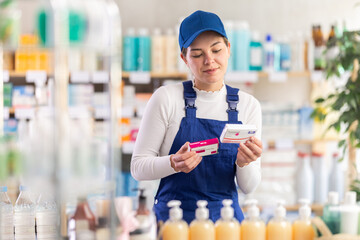 Builder woman in blue overall are busy choosing paracetamol box at pharmacy, compare price and...