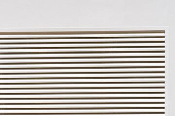 Obraz premium Zoom sur des grilles d’aération de couleur crème, intégrées discrètement dans une façade ou un mur clair.