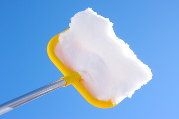 Yellow snow shovel is stuck in a pile of snow