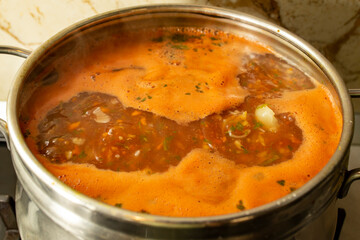 Boiling tomato soup with bubbles and foam, soft focus close up
