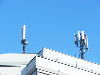 Two tall towers with antennas on top of a building
