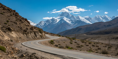 Winding Asphalt Road Through Steep Canyon Towards Snow Covered Mountain PeakWinding Asphalt Road Through Steep Canyon Towards Snow Covered Mountain Peak