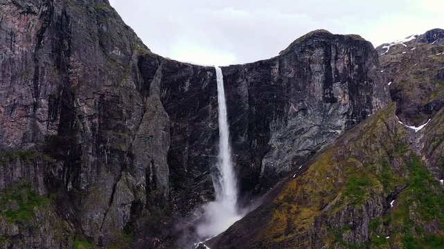 Aerial view of Mardalsfossen, a dramatic waterfall cascading down a sheer rock face, contrasting with the green vegetation, Eikesdal, More og Romsdal, Norway.