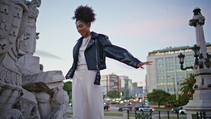 Adventurous woman posing landmark city square. Smiling african lady walking