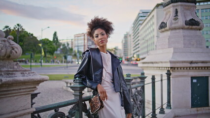 African woman posing urban square by historical landmark closeup. Posh lady