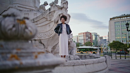 African woman enjoy sightseeing standing at edge beautiful Lisbon fontaine. 