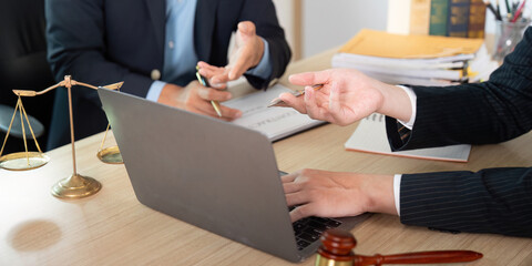 Legal Meeting. Lawyer and client reviewing case documents at desk.