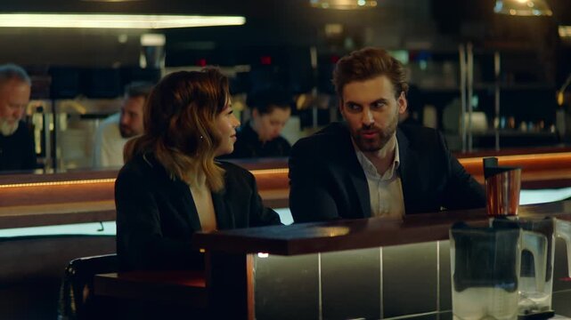 Beautiful Caucasian couple having a date in a stylish restaurant, talking and laughing. Shot with 2x anamorphic lens