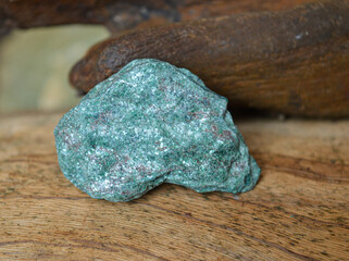 Fuchsita mineral stone on a wood background
